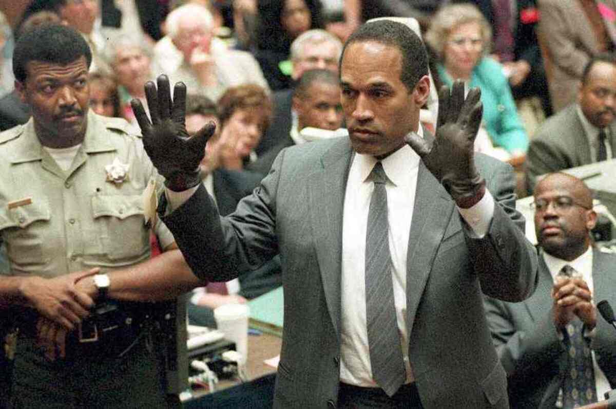 Durante o julgamento por duplo homicídio, O.J. experimenta as luvas apontadas pela acusação como as usadas pelo assassino