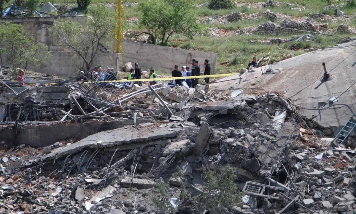Pessoas se reúnem em torno de um prédio destruído alvo de ataques aéreos israelenses no vale de Bekaa, no Líbano - (crédito: AFP)
