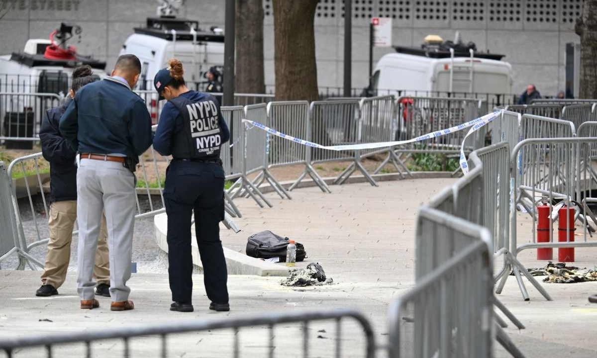 Policiais e peritos no local da imolação, em frente ao tribunal  -  (crédito:  AFP)