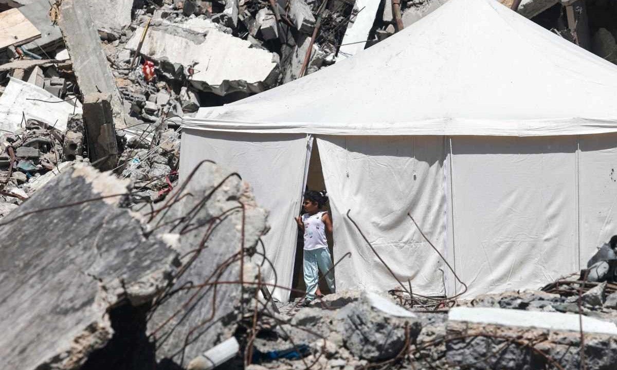 Tenda montada entre os escombros de um edifício danificado por bombardeio israelense em Rafah, na Faixa de Gaza -  (crédito: MOHAMMED ABED/AFP)