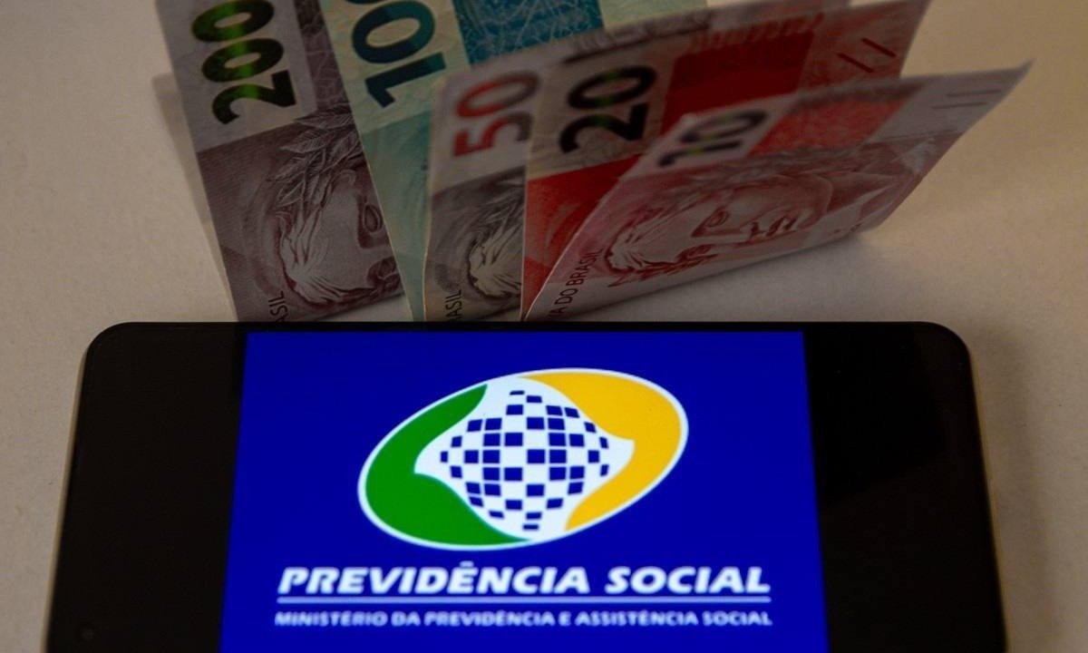  Celular exibe tela da Previdência Social, junto a notas de real; imagem meramente ilustrativa -  (crédito:  Adriana Toffetti/Ato Press/Folhapress)