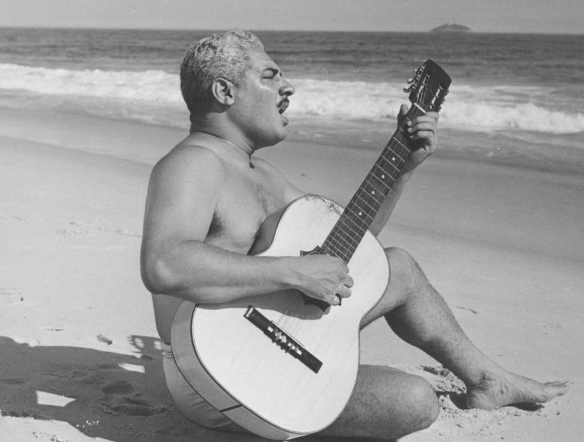 Dorival Caymmi toca violão e canta na praia