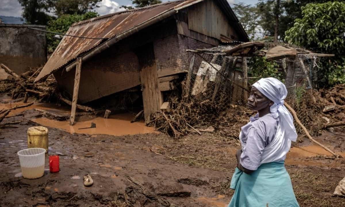 Mulher avalia danos em frente à casa destruída em área afetada por chuvas torrenciais e inundações e onde barragem rompeu as margens - (crédito: LUIS TATO / AFP)