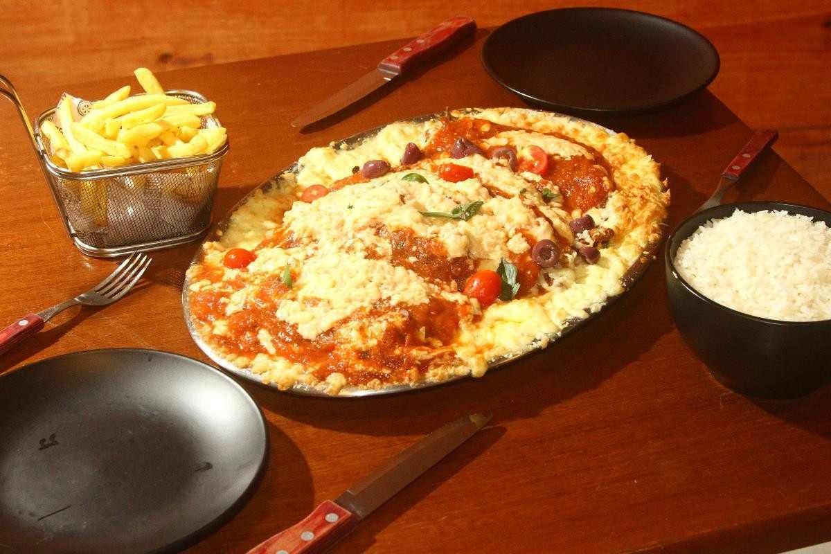 Parmegiana, arroz, batata frita e purê de batatas em mesa