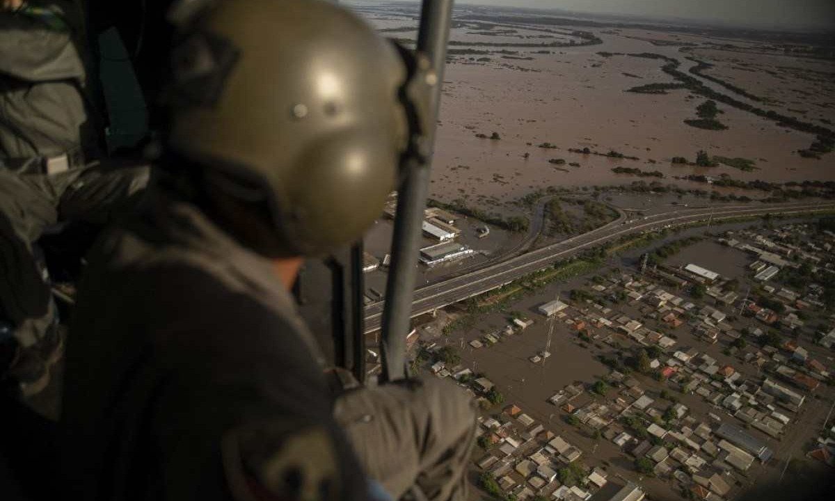  Militar observa de dentro de um helicóptero a situação de área inundada em Porto Alegre (RS) -  (crédito: Carlos FABAL / AFP)