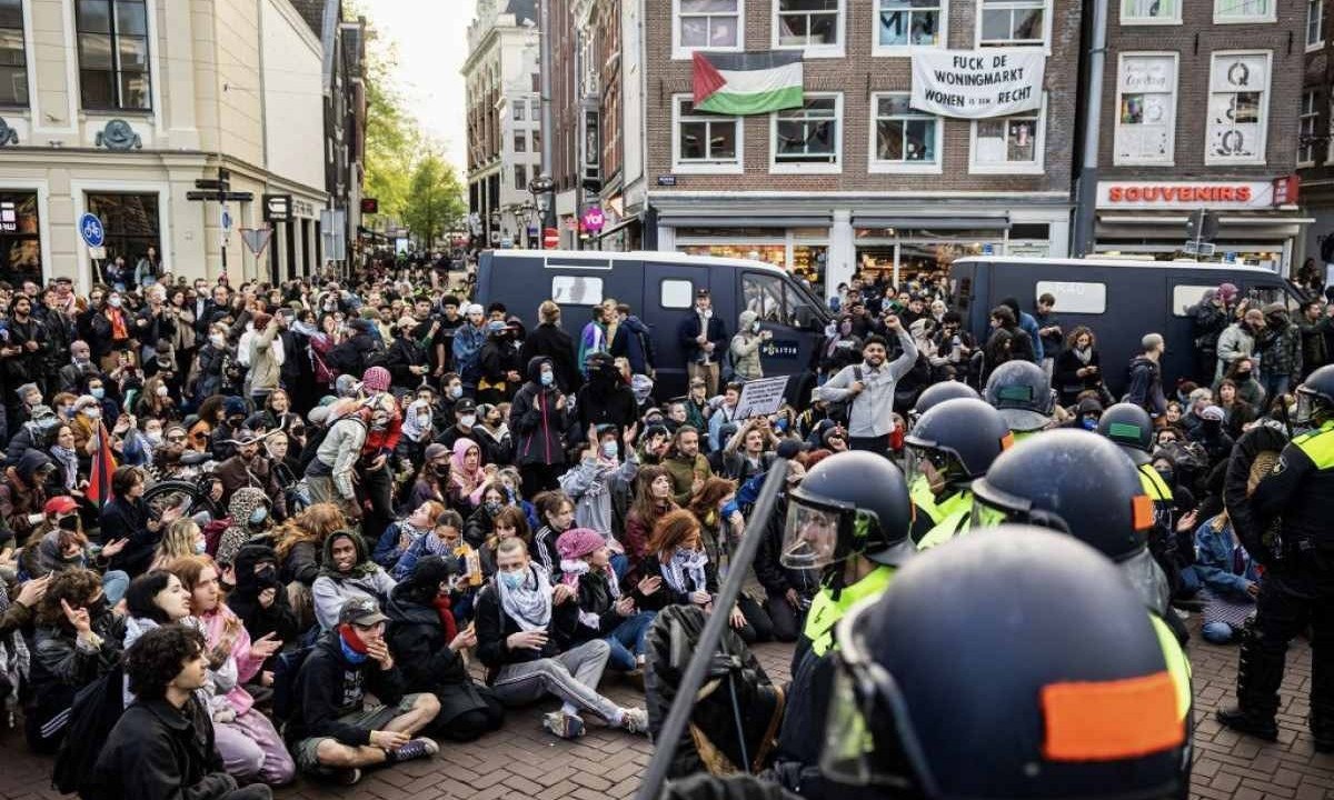 Policiais holandeses montam guarda diante dos manifestantes no Rokin que apoiam estudantes pró-palestinos que ocupam a UvA, pedindo que a universidade corte todos os laços com Israel por causa de ofensiva militar em Gaza - (crédito: Ramon van Flymen / AFP)
