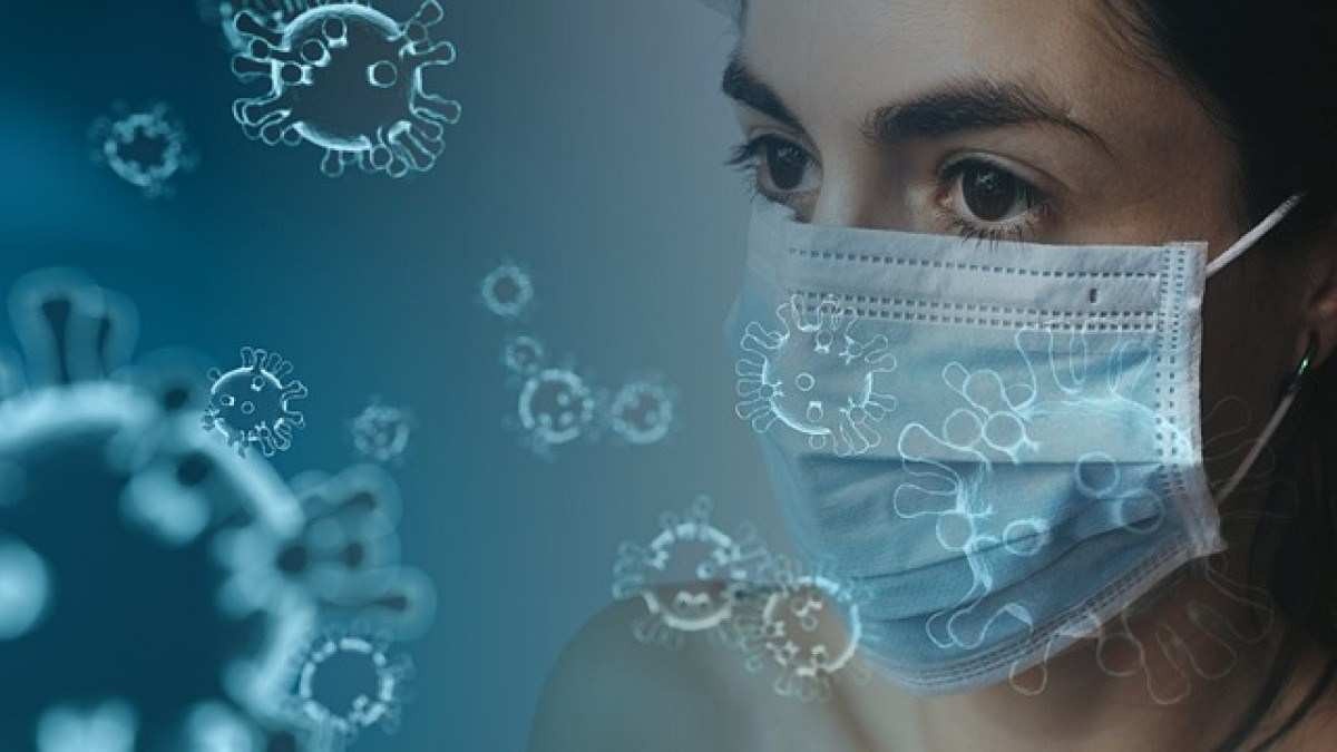 mulher com máscara e cercada por ilustrações de vírus