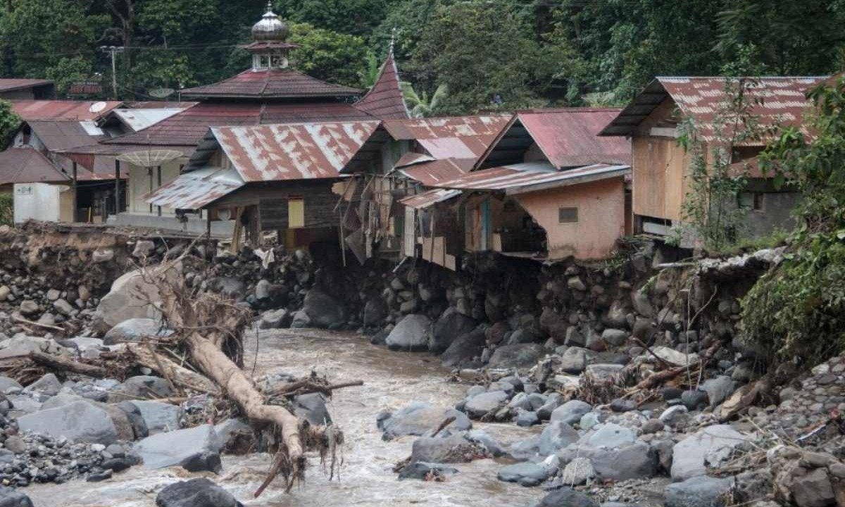 Casas danificadas são vistas após inundações repentinas e fluxo de lava fria de um vulcão em Tanah, na Ilha de Sumatra -  (crédito: REZAN SOLEH / AFP)