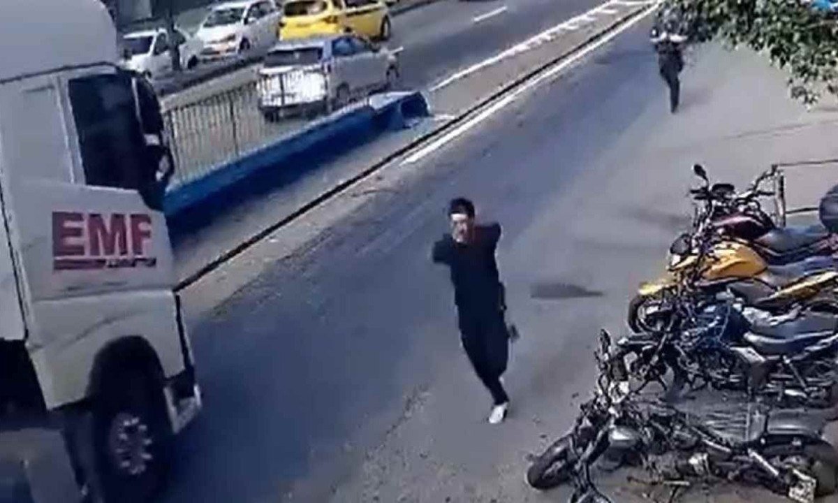 Cena foi flagrada por câmera de segurança e viralizou nas redes sociais; assaltante com as mãos para o alto por causa da algema, sai em disparada por uma avenida -  (crédito: reprodução / Redes sociais)