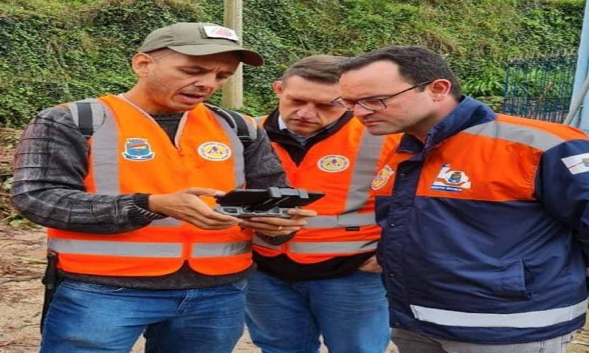 três homens olhando para objeto