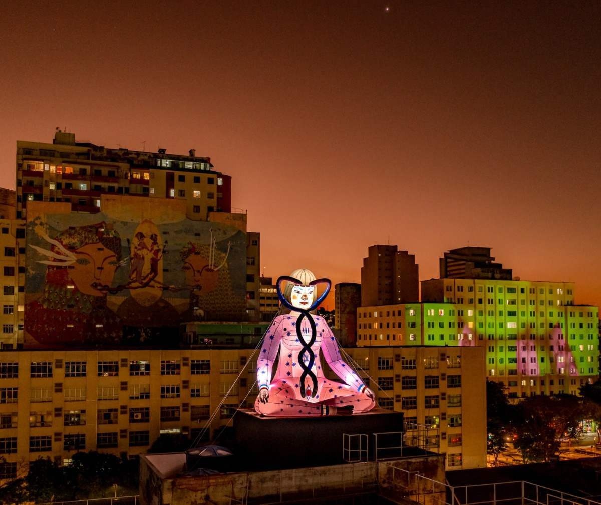 Figura iluminada de um monge gigante em prédio do Centro de BH