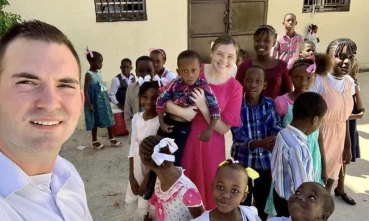 Os missionários norte-americanos Davy e Natalie Lloyd posando com crianças haitianas -  (crédito: MISSIONS IN HAITI / AFP)