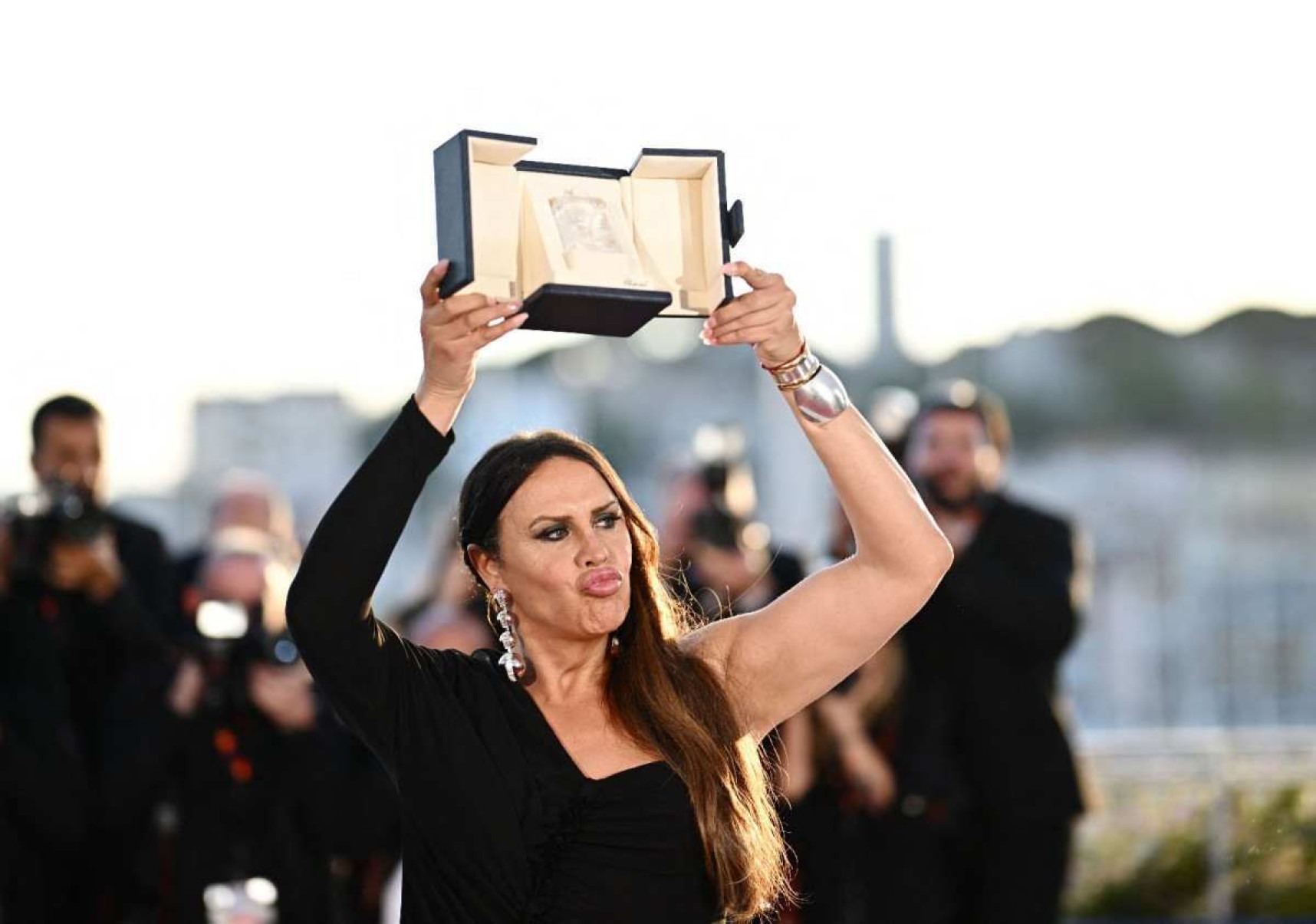 A atriz trans espanhola Karla Sofia Gascón ergue o troféu recebido em Cannes