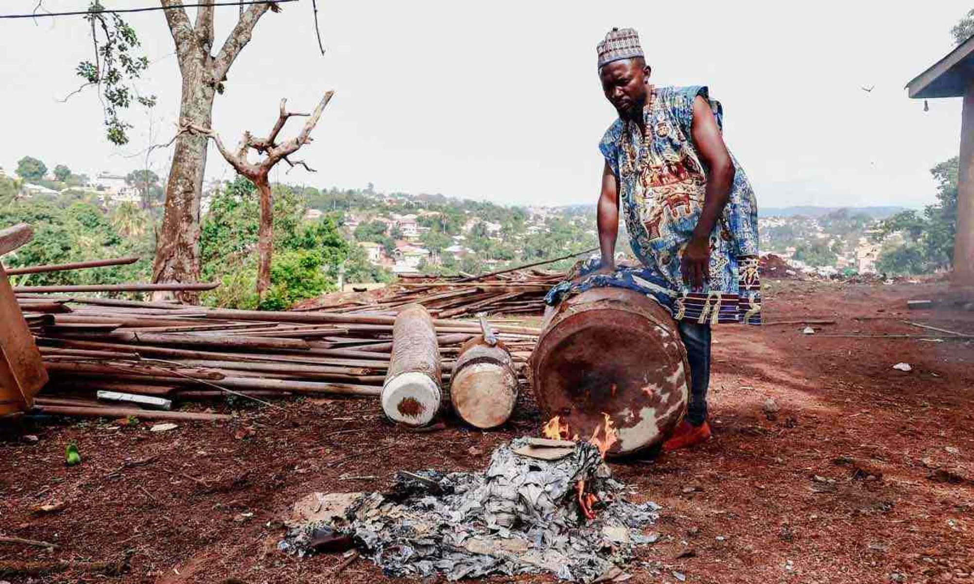 Músico aquece a pele do seu tambor antes da celebração