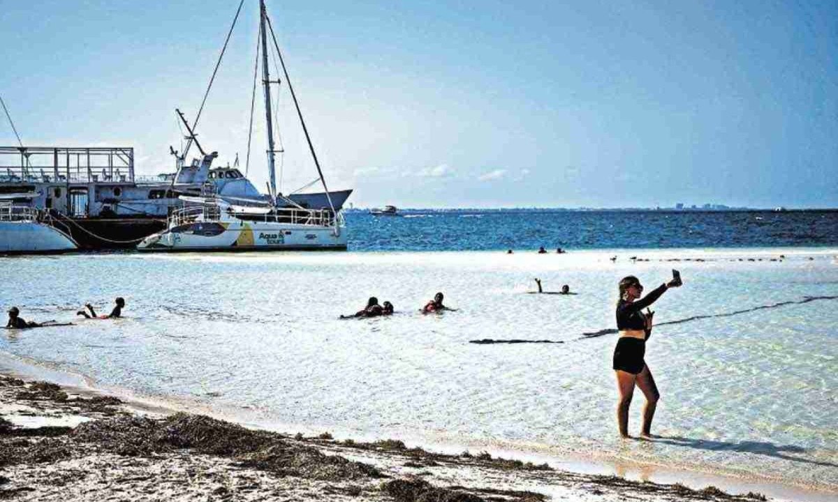 Banhista tira selfie em praia de Cancún: luxo e pobreza -  (crédito: afp)