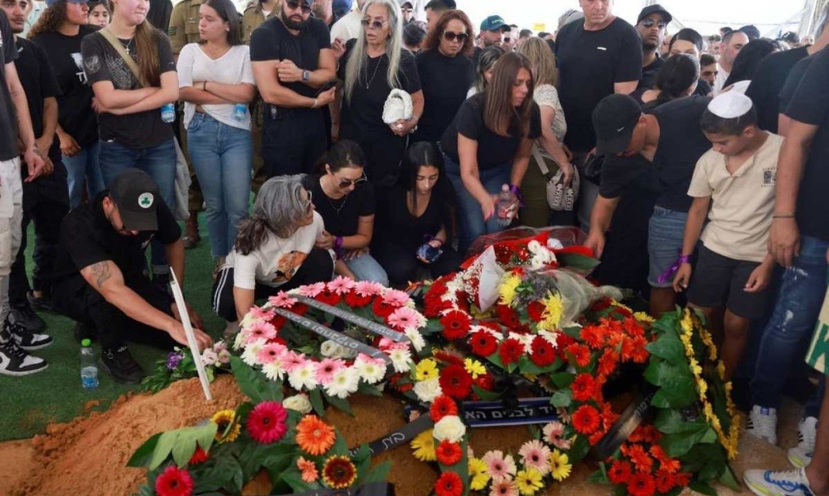 Parentes e amigos choram no túmulo durante o funeral do soldado israelense Almog Shalom, no Cemitério Militar Mount Herzl, em Jerusalém; ele foi morto com outros três soldados na Faixa de Gaza - (crédito: Menahem Kahana / AFP )