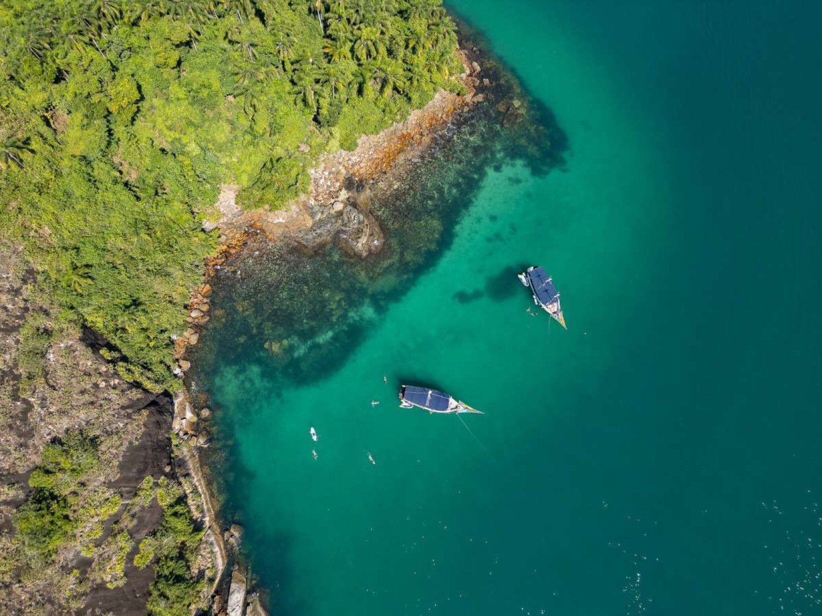 Passeio de escuna, sobre o mar de água esverdeada, passa por belas ilhas da região 