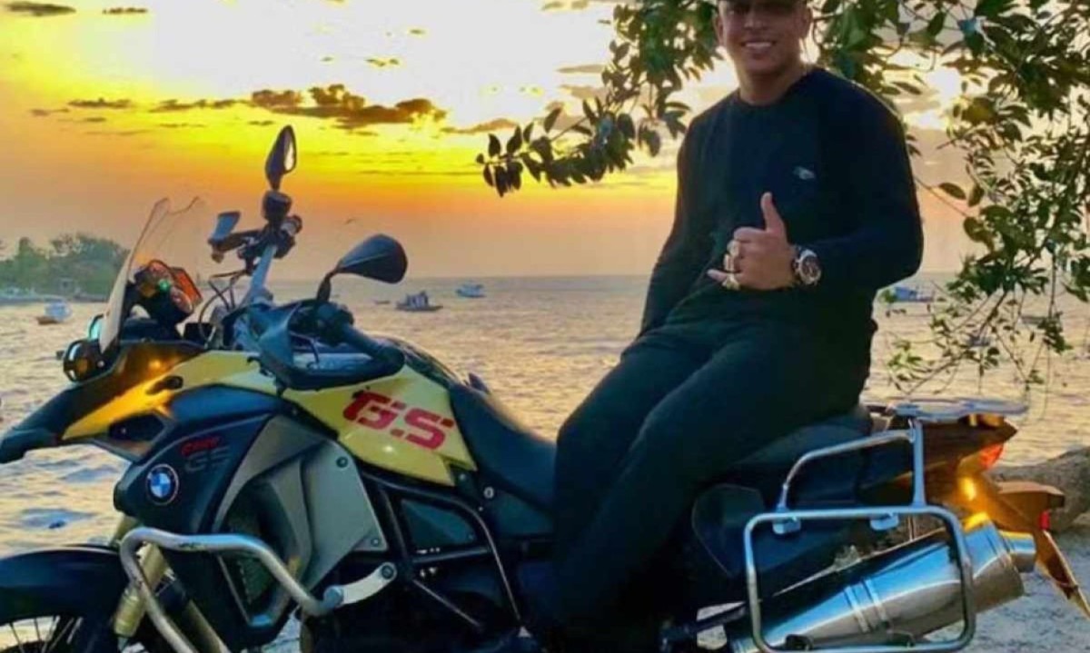  Douglas Emanuel Vilela de Oliveira faz sinal de 'legal' com a mão esquerda, sentado em moto, no pôr do sol -  (crédito: Reprodução / Redes Sociais)