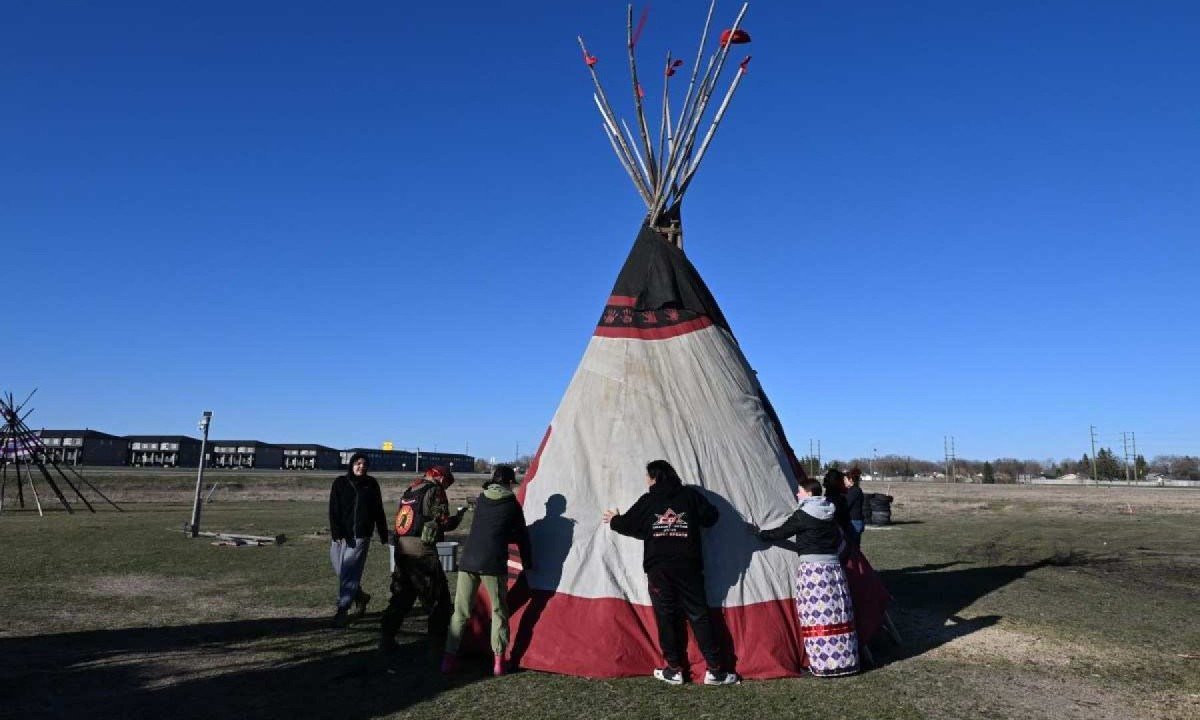 Família e amigos se preparam para montar tenda cerimonial em homenagem ao assassinado Morgan Harris e outras indígenas desaparecidas e assassinadas, no "Camp Morgan" em Winnipeg, Canadá -  (crédito: Sebastien ST-JEAN / AFP)
