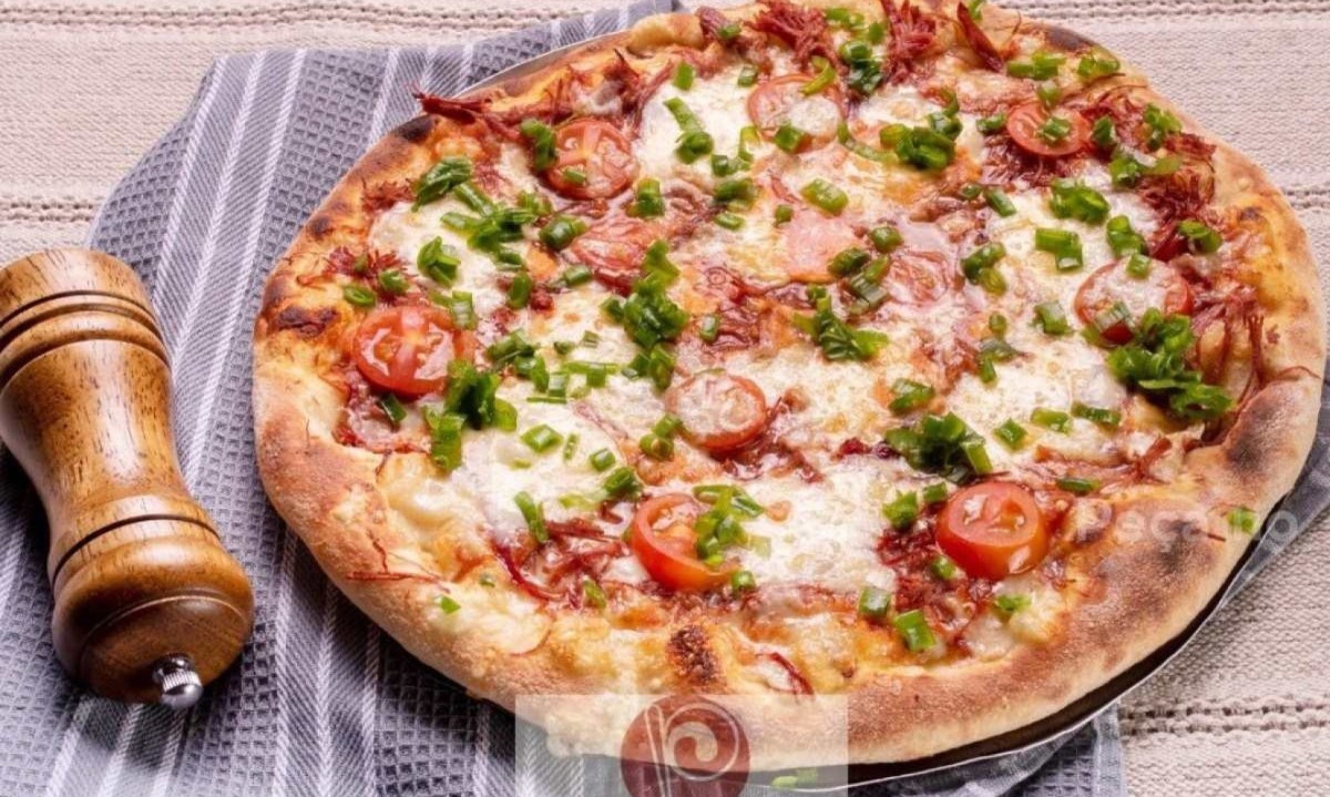 Pizza Estrada Real (muçarela, molho de tomate, carne seca, queijo canastra, tomate cereja e cebolinha) da Pizzarella