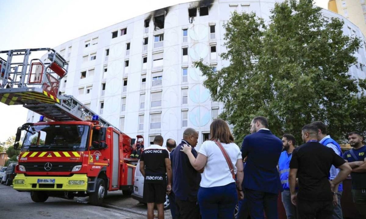  Mulher conforta um homem, parente de vítimas do incêndio em prédio residencial de Nice, na França -  (crédito: Valery HACHE / AFP)