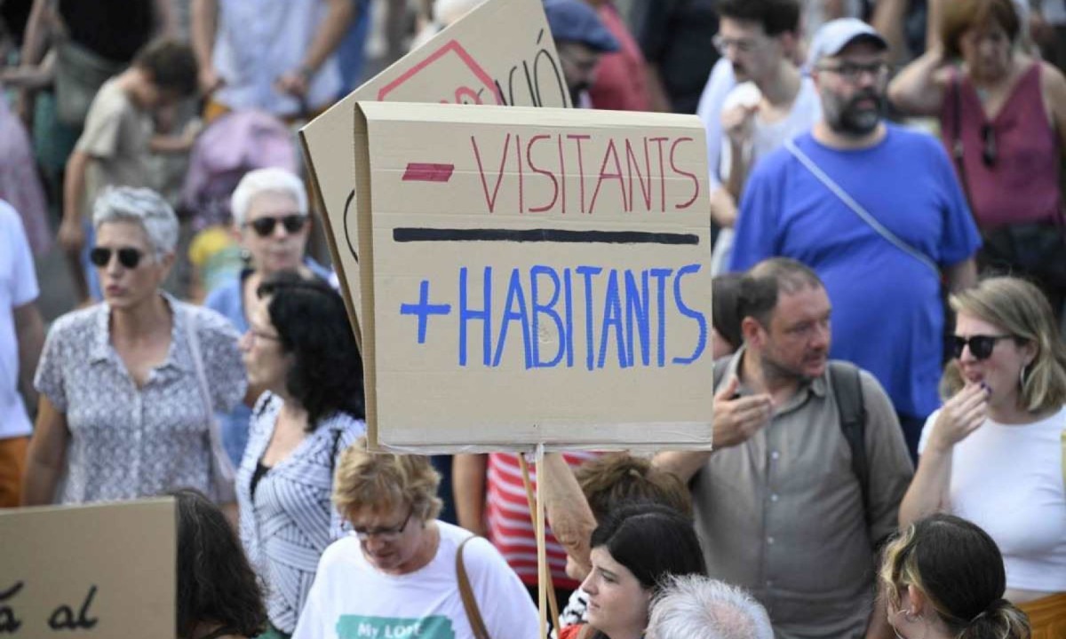 Manifestantes marcham durante um protesto contra o turismo de massa no beco Las Ramblas de Barcelona, ??em 6 de julho de 2024 -  (crédito: Josep Lago/AFP)