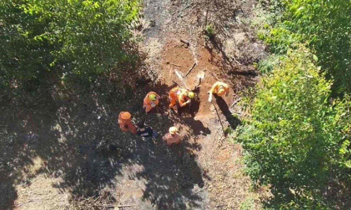 Momento em que soldados do Corpo de Bombeiros desenterravam a ossada em fazenda -  (crédito: PCMG)