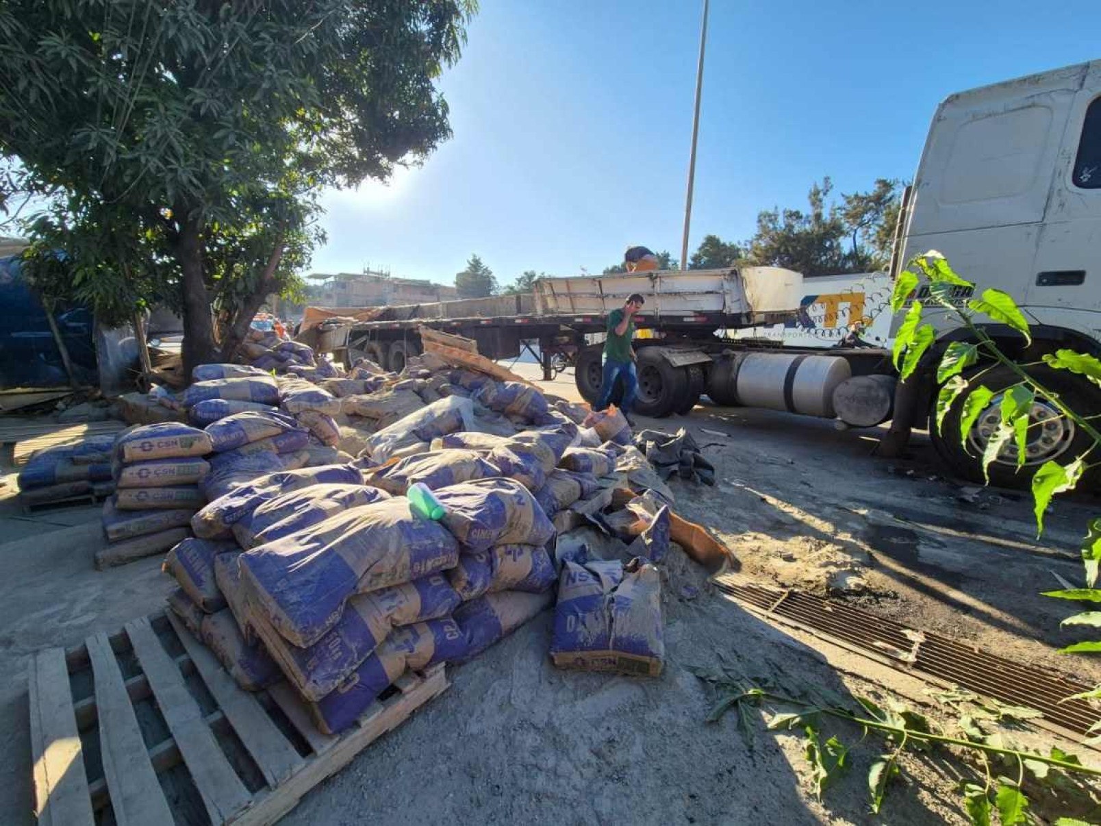 Carreta carregada de cimento tomba no Anel Rodoviário e atinge casas e carros