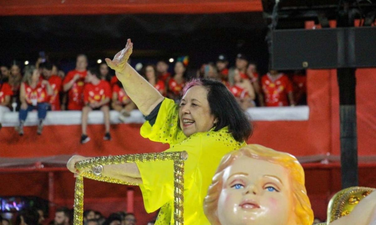 Rosa Magalhães, carnavalesca da Imperatriz Leopoldinense, acena para o público durante desfile; ela morreu aos 77 anos -  (crédito: Talita Giudice / Super Rádio Tupi)