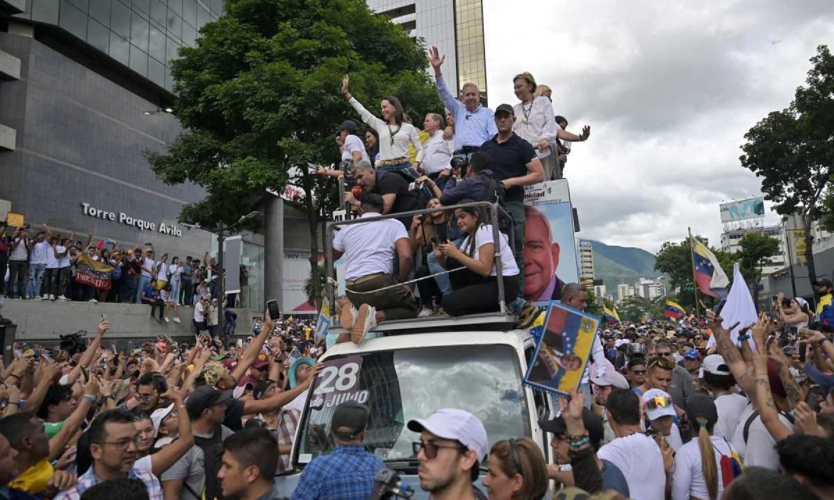 Liderados por Maria Corina Machado e Gonzalez Urrutia (no carro, com os braços levantados) multidão pede mudança de governo -  (crédito:  AFP)