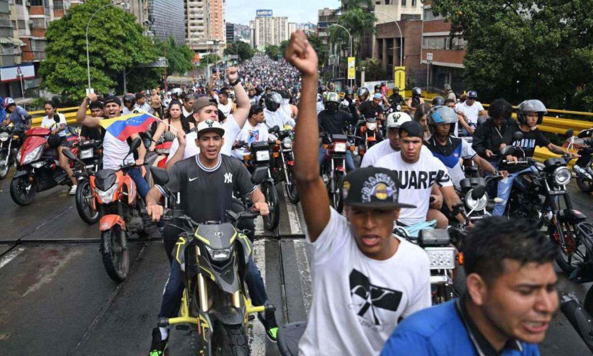 Um oponente do governo do presidente venezuelano Nicolás Maduro queima cartazes da campanha do atual presidente durante um protesto em Petare -  (crédito: Getty Images)