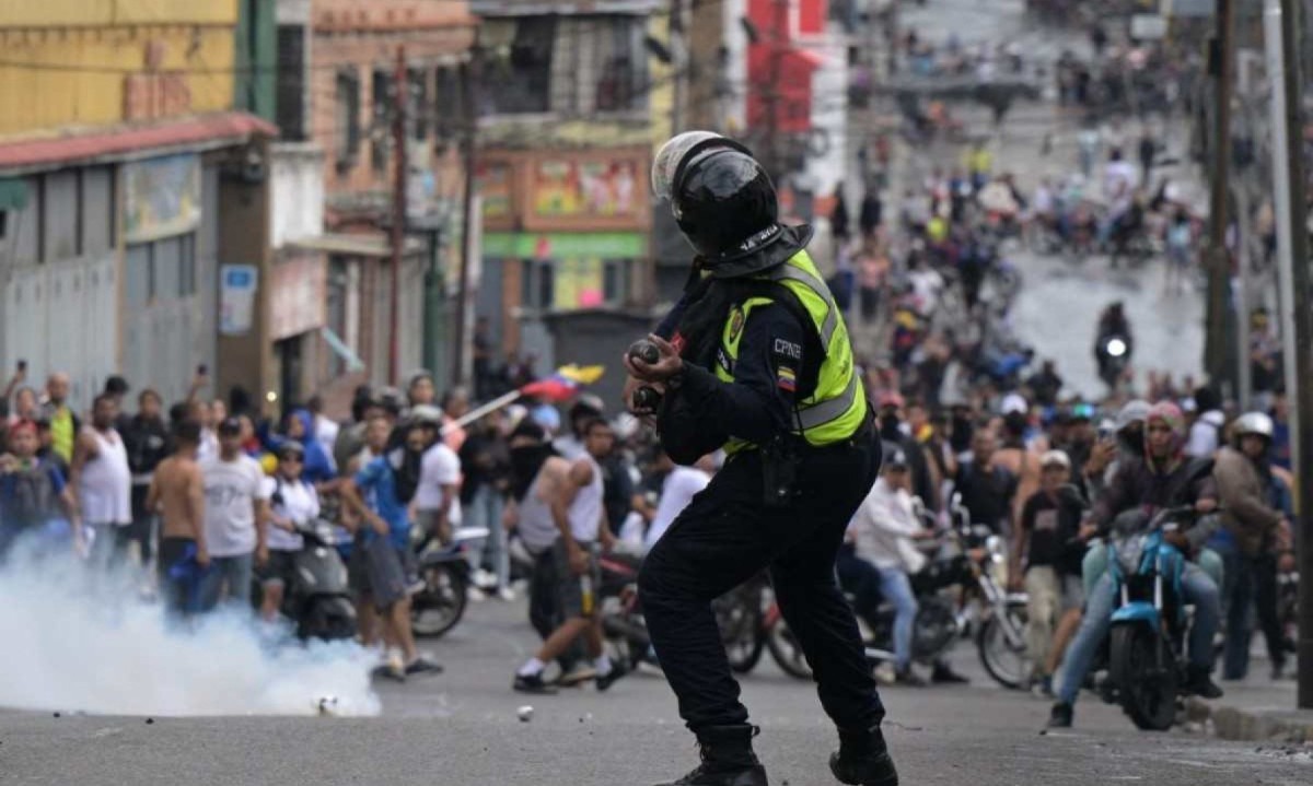 Policial de choque usa gás lacrimogêneo contra manifestantes durante um protesto de oponentes do governo do presidente venezuelano Nicolás Maduro em Caracas
       -  (crédito:   Yuri CORTEZ / AFP )