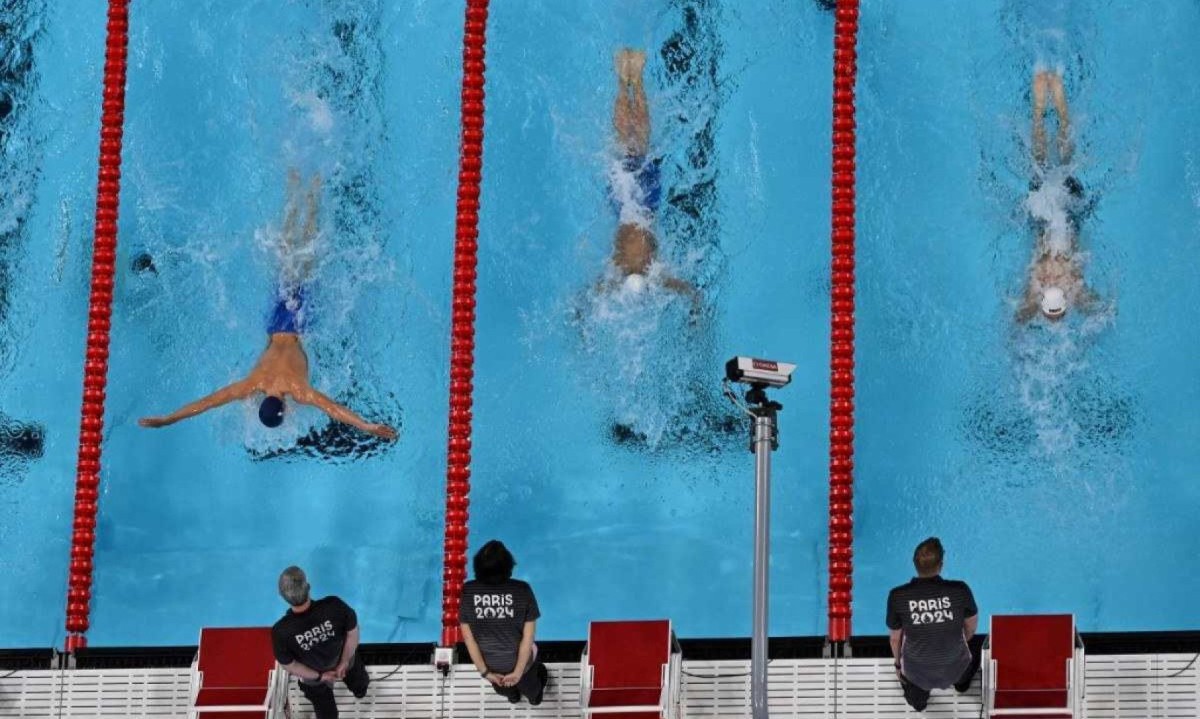  Árbitros observam nadadores em piscina da Olimpíada de Paris 2024 -  (crédito: Jonathan NACKSTRAND / AFP)