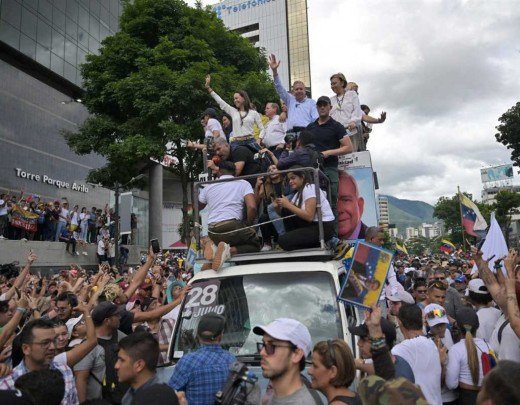Liderados por Maria Corina Machado e Gonzalez Urrutia (no carro, com os braços levantados) multidão pede mudança de governo -  (crédito:  AFP)