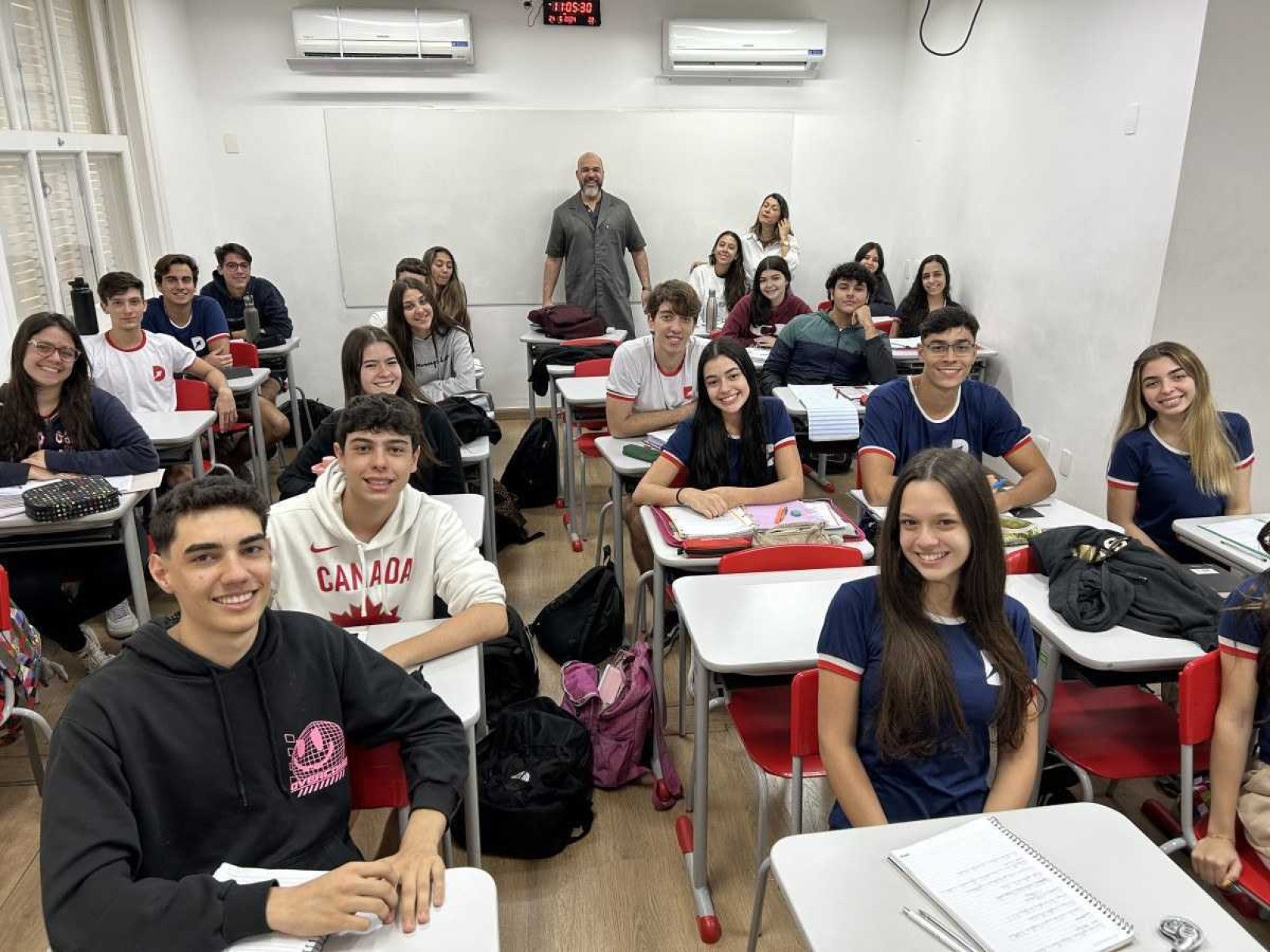 Alunos dentro de uma sala de aula com os professores.