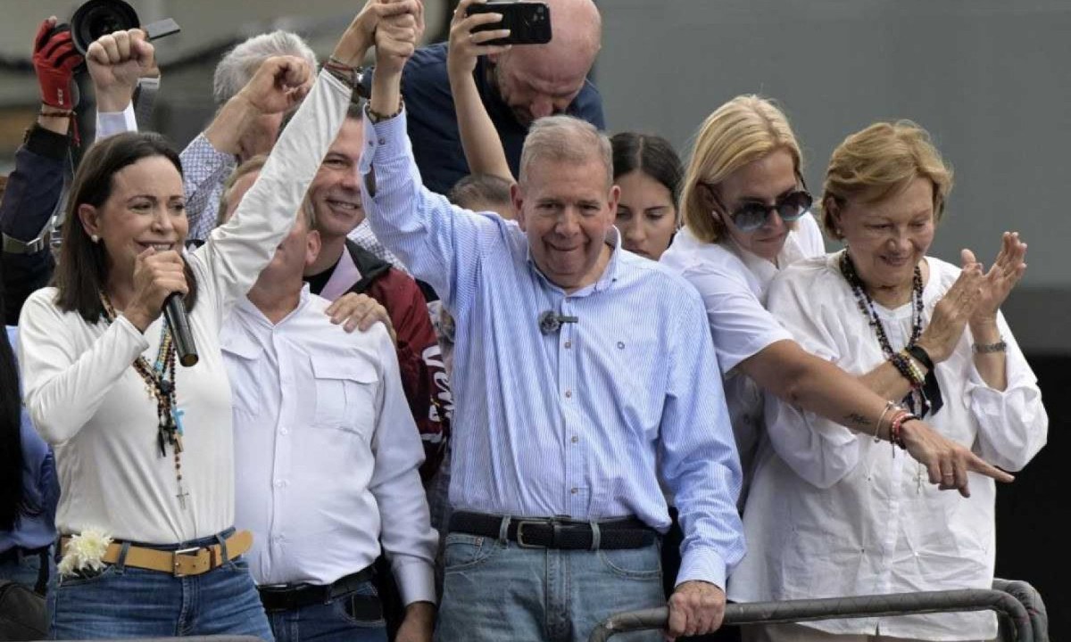 Líder da oposição venezuelana Maria Corina Machado levanta mão esquerda do candidato presidencial da oposição Edmundo Gonzalez Urrutia em comício em frente à sede das Nações Unidas em Caracas
       -  (crédito: Yuri Cortez/AFP)