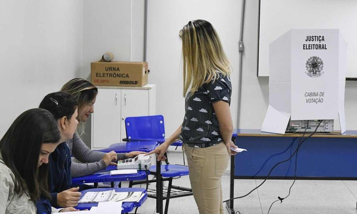  Seção eleitoral em funcionamento, com mesários atendendo eleitora -  (crédito:  Edilson Rodrigues/Agência Senado)