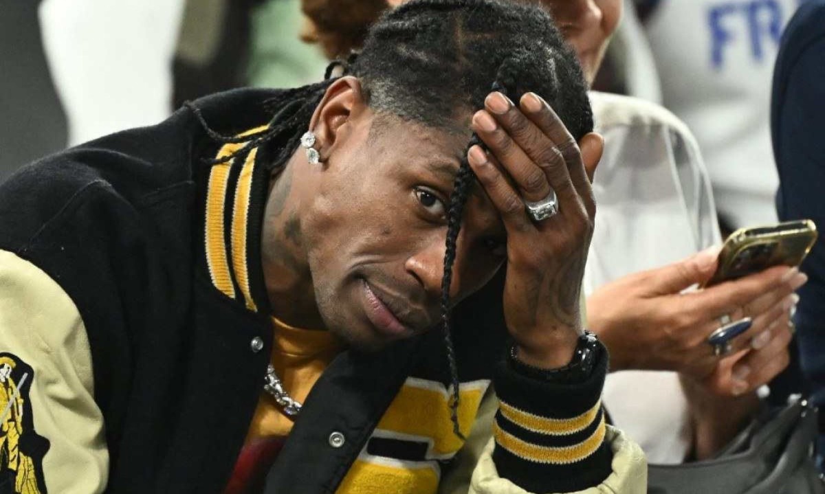 Rapper Travis Scott com uma das mãos na cabeça durante a semifinal do basquete olímpico em Paris -  (crédito: Aris MESSINIS / AFP)