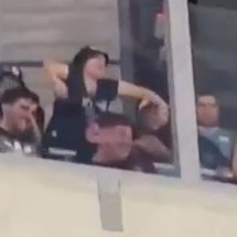 Torcedora do Belgrano faz gestos de macaco com os braços em direção à torcida do Athletico -  (crédito: Foto: Reprodução)