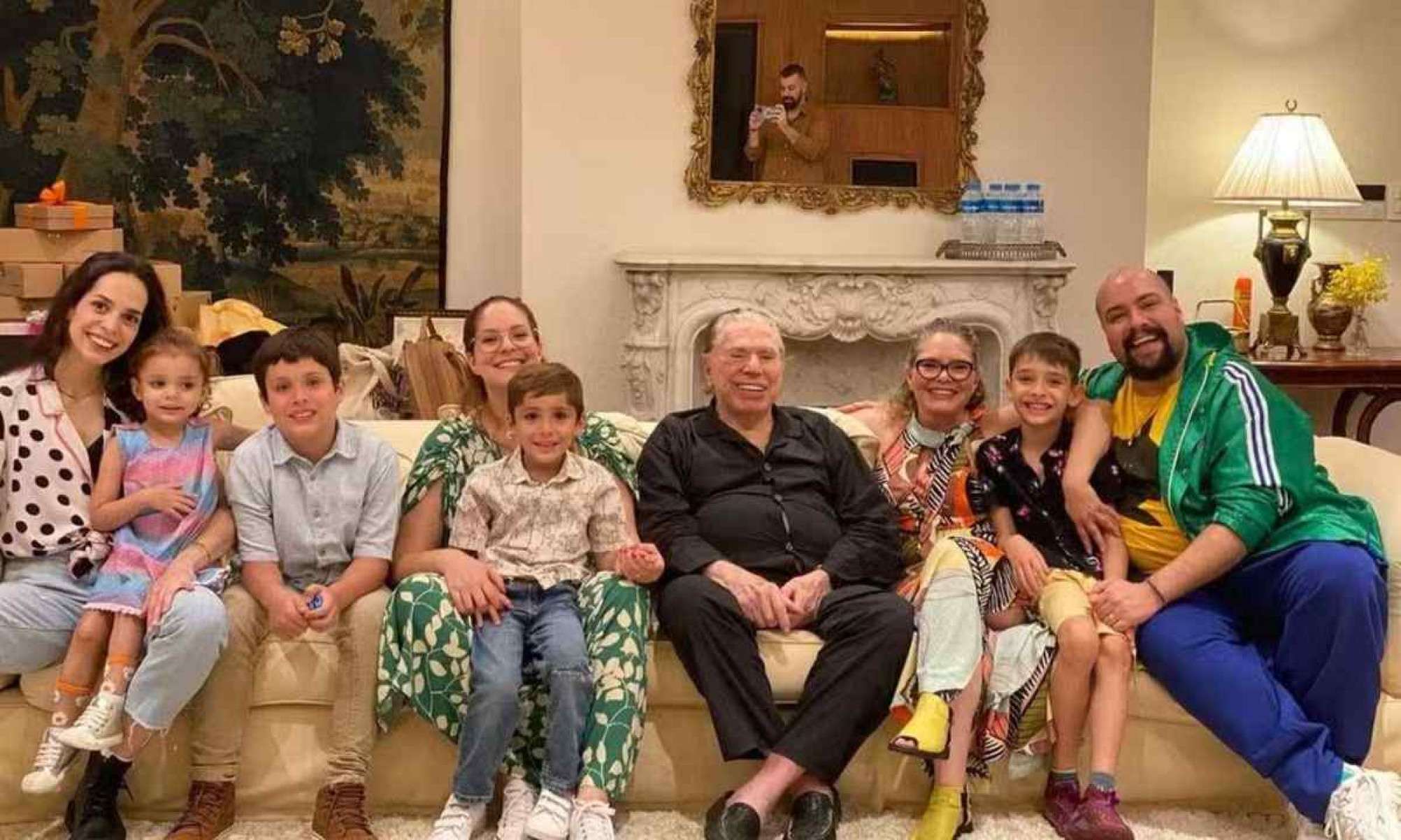 Silvio junto com os netos em sua sala repleta de obras de arte