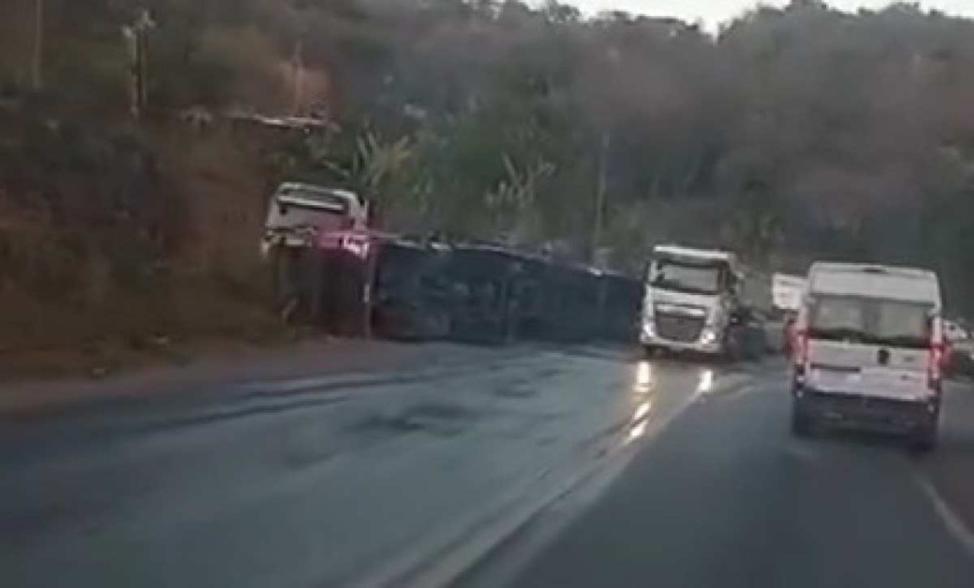 Carreta bitrem tomba, espalha óleo na pista e fecha BR-381