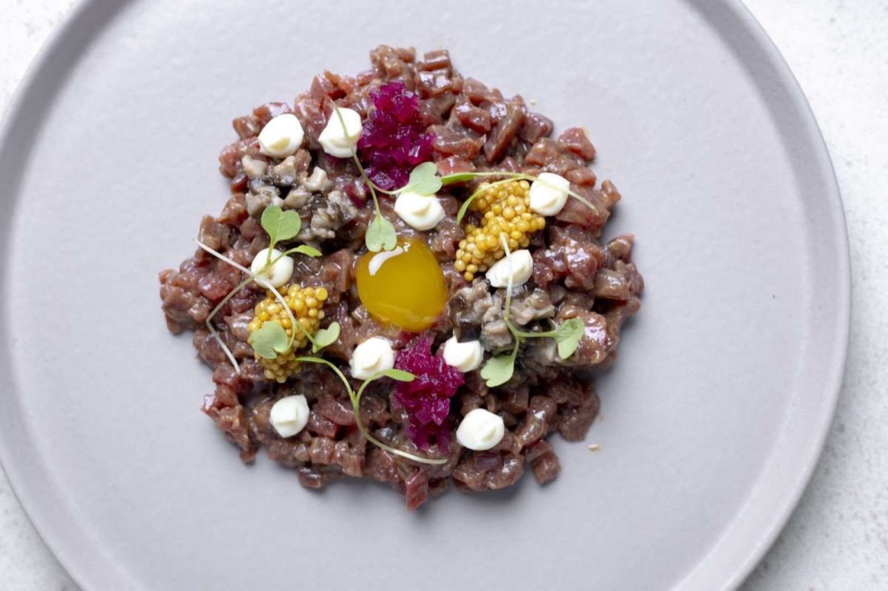 Steak tartare com picles de cogumelo, aioli e mostarda em grãos