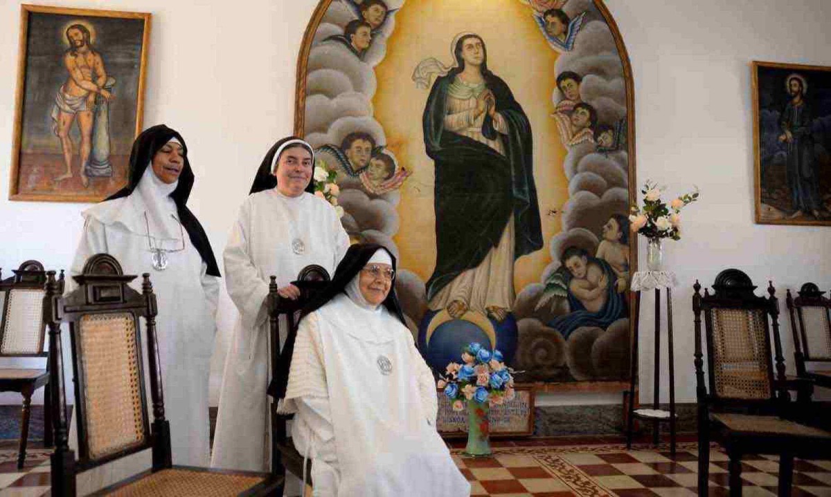 a madre Ana Eliza (E) e as irmãs Marisa de fátima e Maria Imaculada (assentada), diante da pintura da padroeira, Nossa Senhora da Conceição -  (crédito:  Túlio Santos/EM/D.A Press)