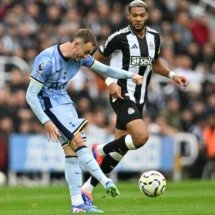 Maddison (do Tottenham, de azul) tenta o arremate. Joelinton, do Tottenham, observa -  (crédito: Foto: Andy Buchanan/AFP via Getty Images)