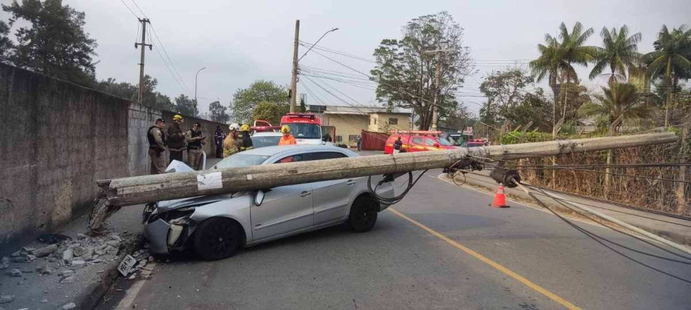 Com o impacto, poste caiu em cima de carro e bloqueou rua de Juiz de Fora -  (crédito: CBMMG)