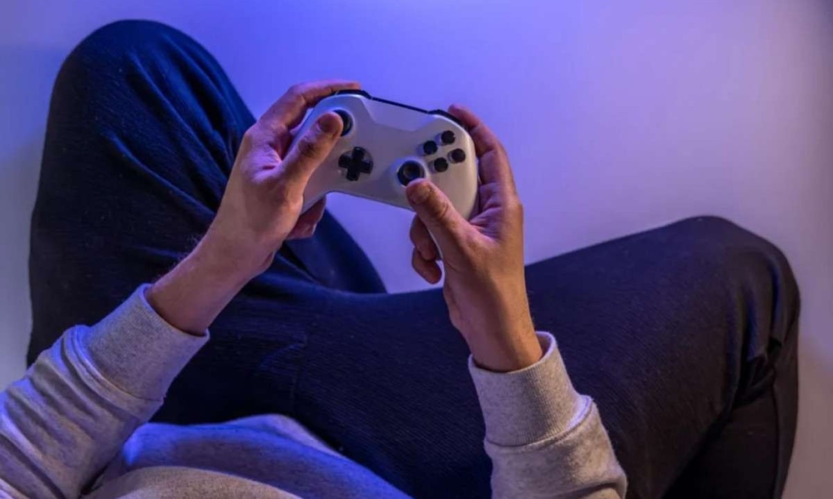 Jovem segurança controle de videogames com as duas mãos; imagem meramente ilustrativa -  (crédito: Freepik)