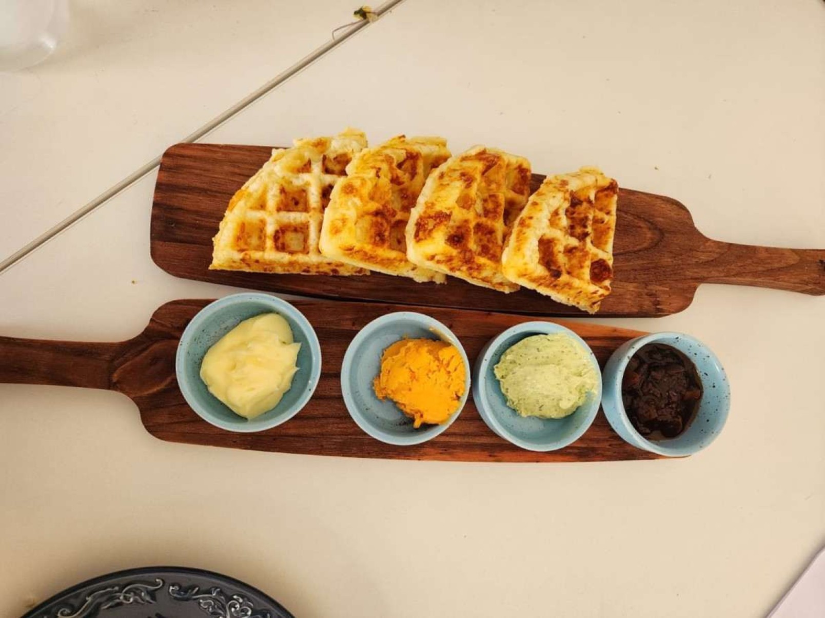 Os waffles de pão de queijo podem ser acompanhados de manteiga de ervas, cream cheese, chutney de tomate e goiabada