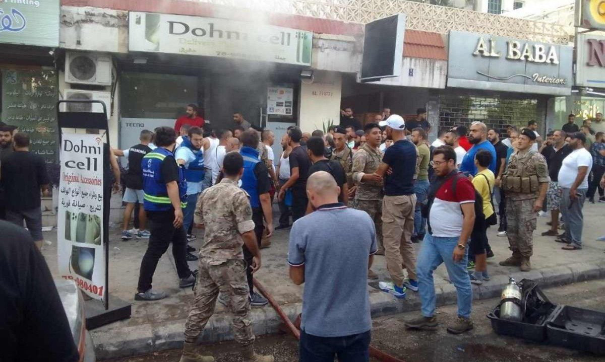 Pessoas e socorristas em frente ao local de uma suposta explosão de dispositivo em Saida, no sul do Líbano, em 18 de setembro de 2024
       -  (crédito: Mahmoud ZAYYAT / AFP)