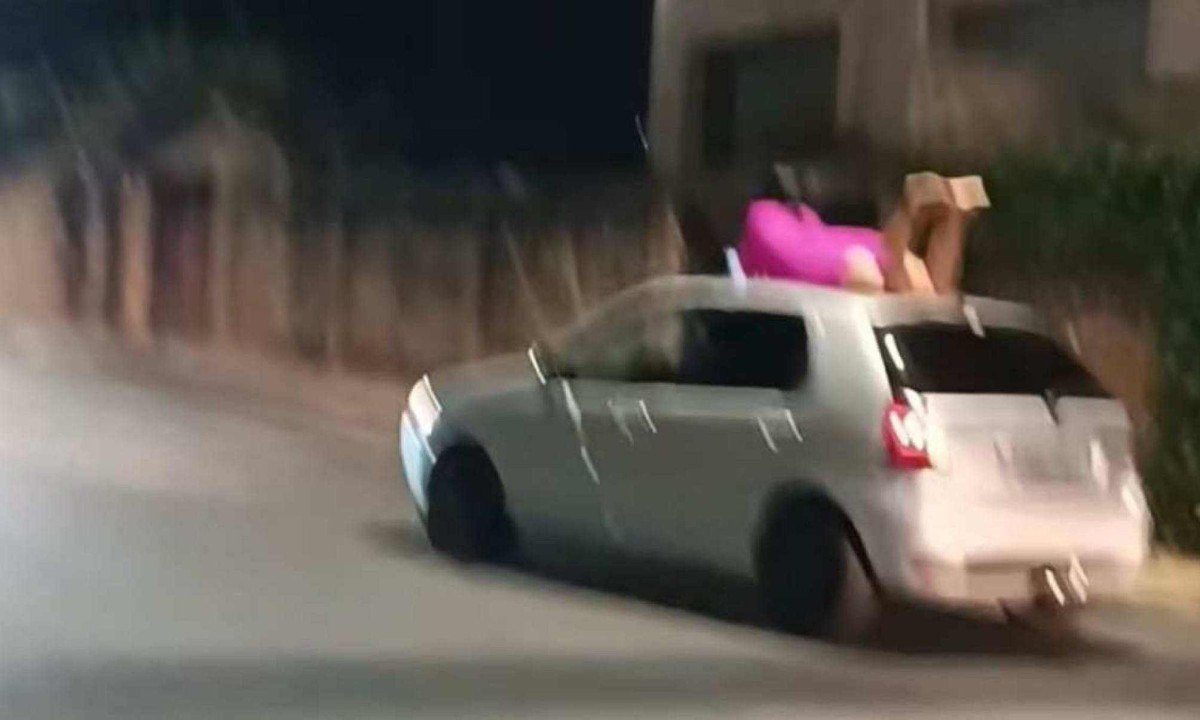 Mulher foi flagrada andando no teto de um carro no Barreiro -  (crédito: Redes Sociais/Reprodução)