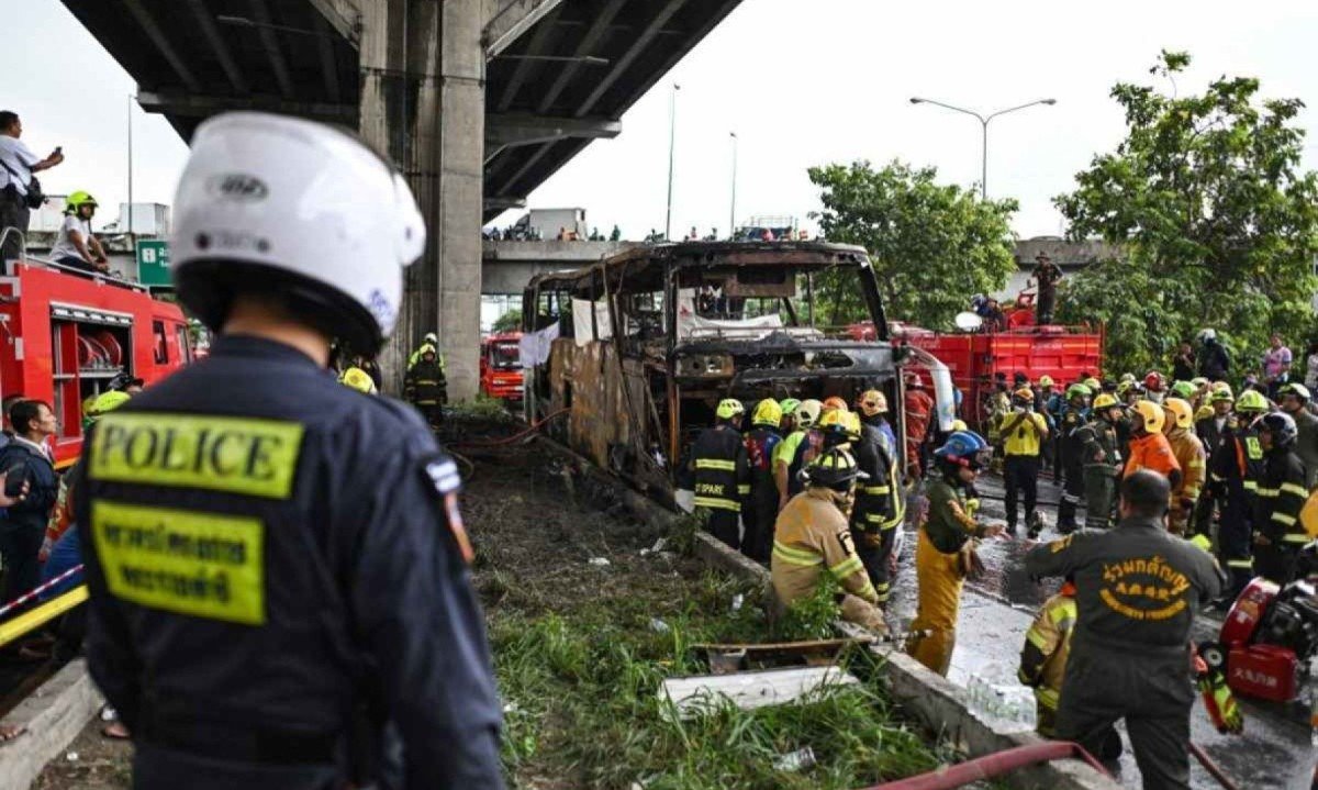 Bombeiros, policiais e equipes de resgate no local onde ônibus que transportava estudantes e professores nos arredores de Bangkok incendiou-se -  (crédito: Manan VATSYAYANA / AFP)